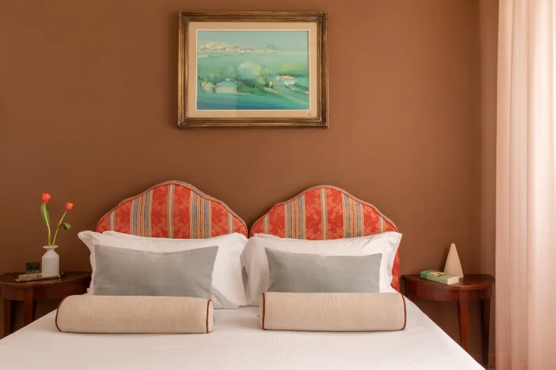 Camera matrimoniale economy con testiera decorata e arredi classici, ideale per soggiorni confortevoli a Pisa - Hotel La Pace, BZAR hotels a Pisa