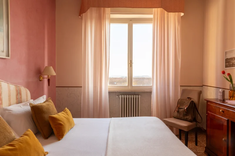 Camera matrimoniale con finestra e arredi eleganti, atmosfera luminosa per soggiorni in hotel a Pisa centro - Hotel La Pace, BZAR hotels a Pisa