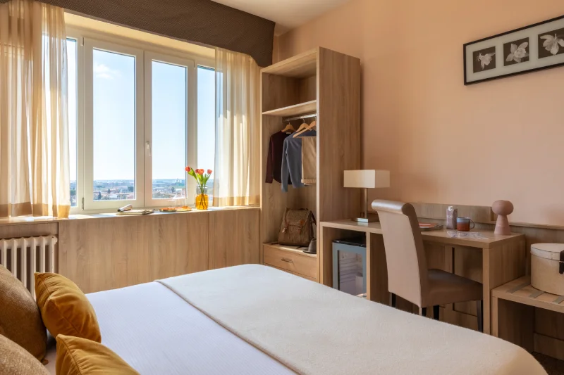 Camera superior con armadio aperto, scrivania e vista esterna, comfort moderno per soggiorni a Pisa centro - Hotel La Pace, BZAR hotels a Pisa